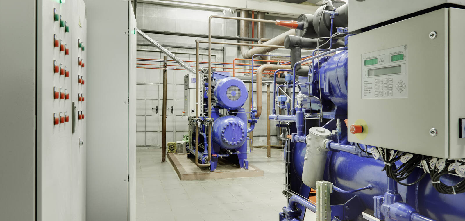 Industrial chilled-water plant interior with chillers and insulated process piping