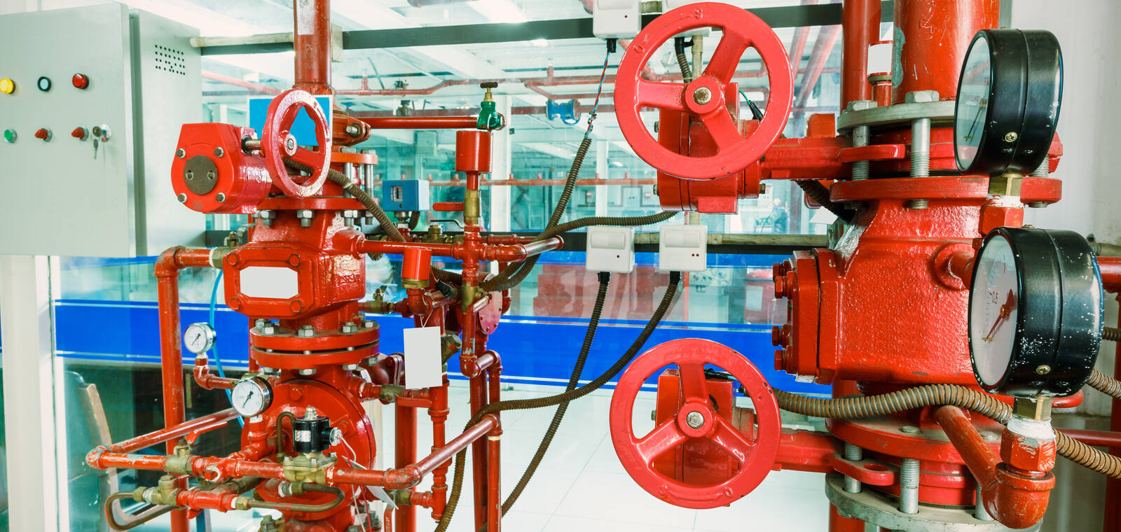 Red fire-protection pipework and valves in an industrial facility