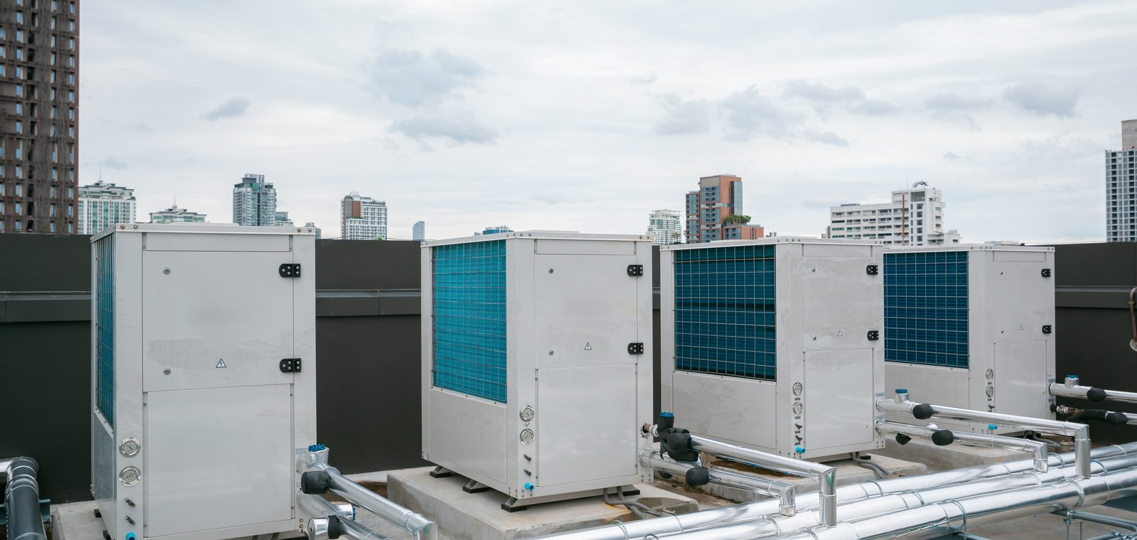 Rooftop condensing units connected by insulated refrigerant pipework on a commercial building