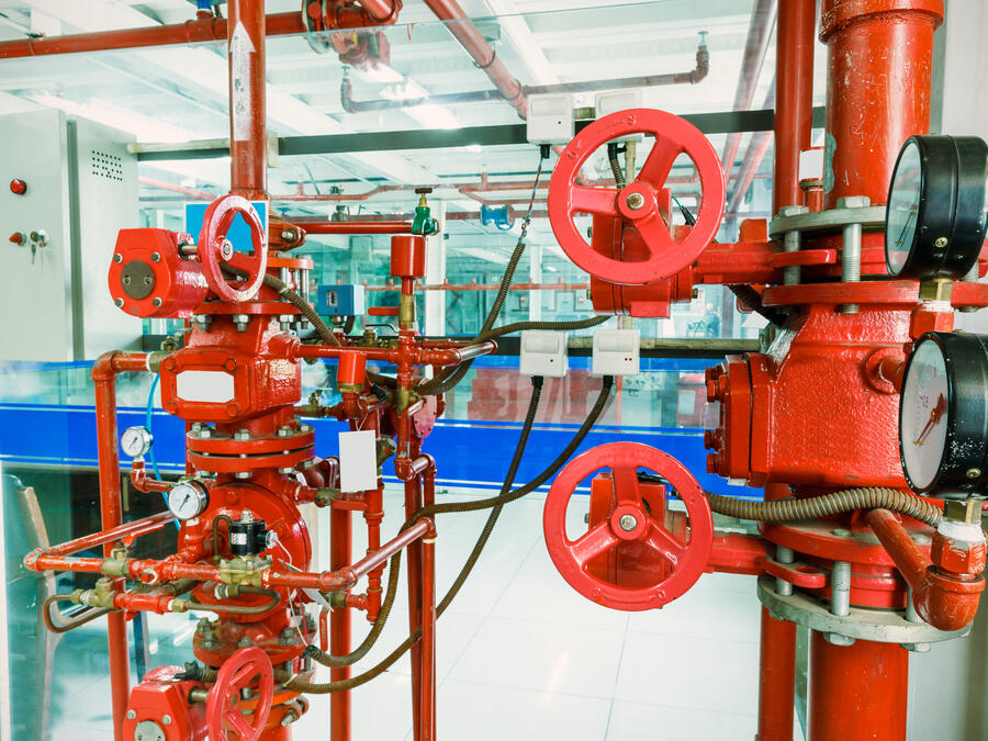 Red fire-protection pipework and valves in an industrial facility