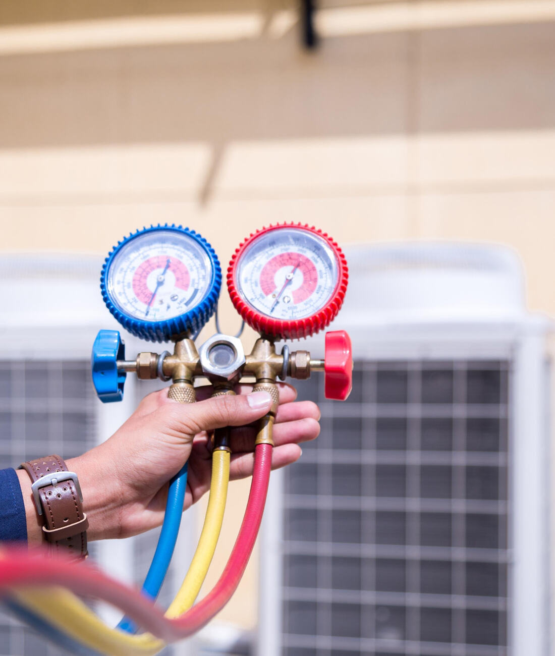 Technician checking refrigerant pressure gauges during system commissioning